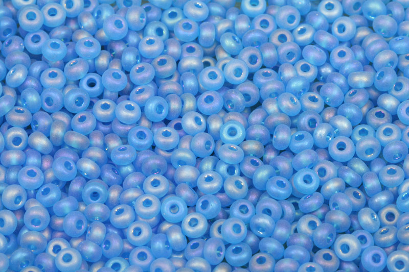 Rokajl Preciosa 6/0 (3,7 - 4,3 mm) RH, bal. 50 g - transp. modrá mat, iris rainbow