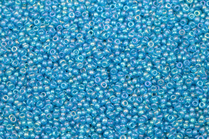 PRECIOSA rokajl 10/0 (2,2 - 2,4 mm) RH, bal. 50 g - transp. akvamarínově modrá, rainbow