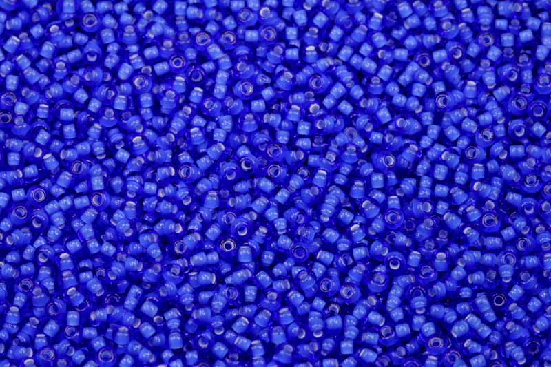 PRECIOSA rokajl 11/0 (2,0 - 2,2 mm) RH, bal. 50 g - transp. safírově modrá, bílý průtah
