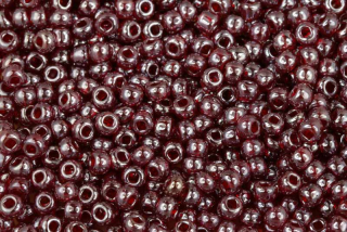 PRECIOSA rokajl 6/0 (3,7 - 4,3 mm) RH, bal. 50 g - transp. tmavě rubín. červená s listrem