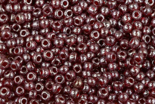 PRECIOSA rokajl 6/0 (3,7 - 4,3 mm) RH, bal. 50 g - transp. tmavě rubín. červená s listrem